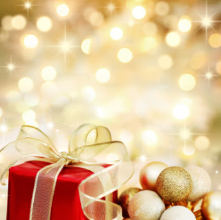 Red Christmas gift box and baubles on background of defocused golden lights.